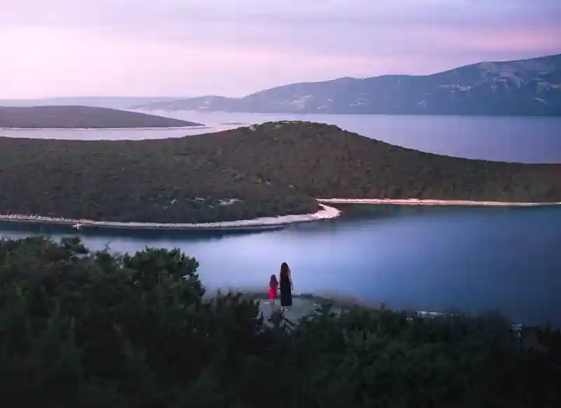 Mamma e figlia con lago sullo sfondo